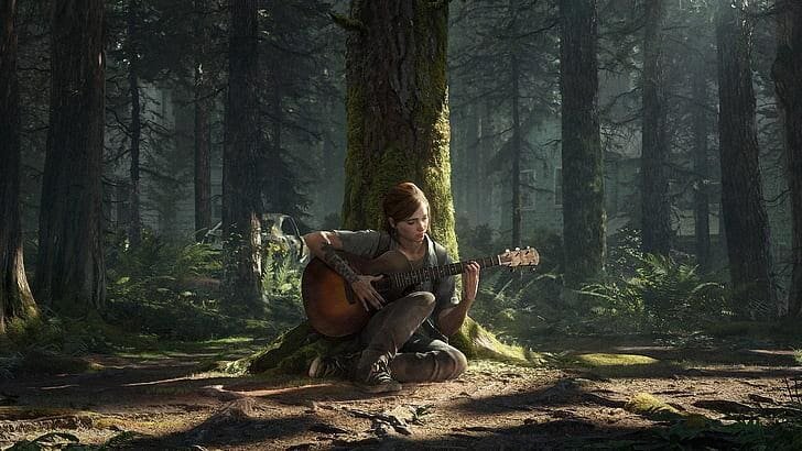 Ellie playing guitar by a tree.