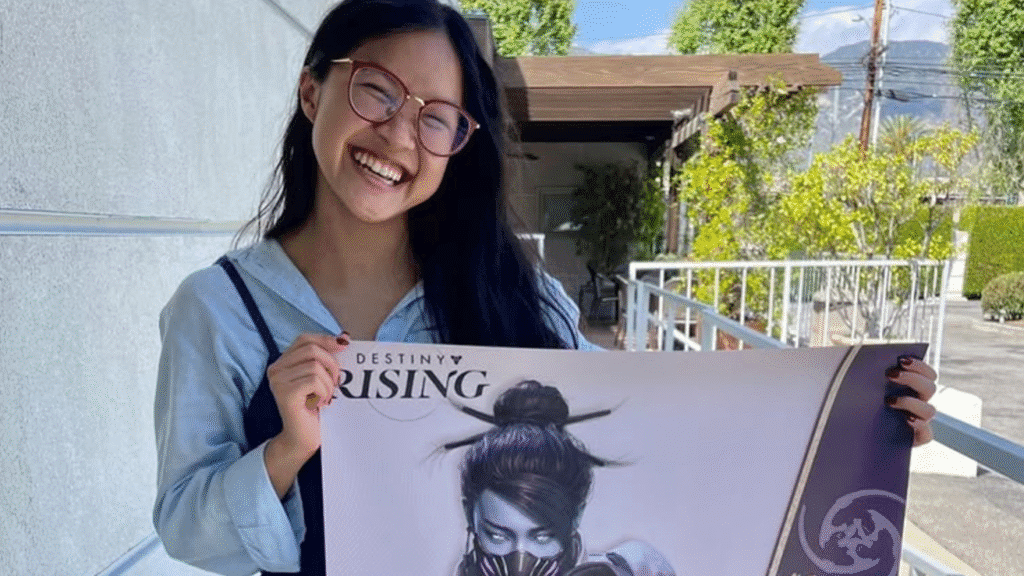 standing holding a poster of the character she is going to voice in Destiny Rising