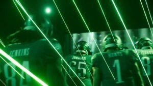 Players walking through the tunnel as green lasers shoot down in Madden NFL 26